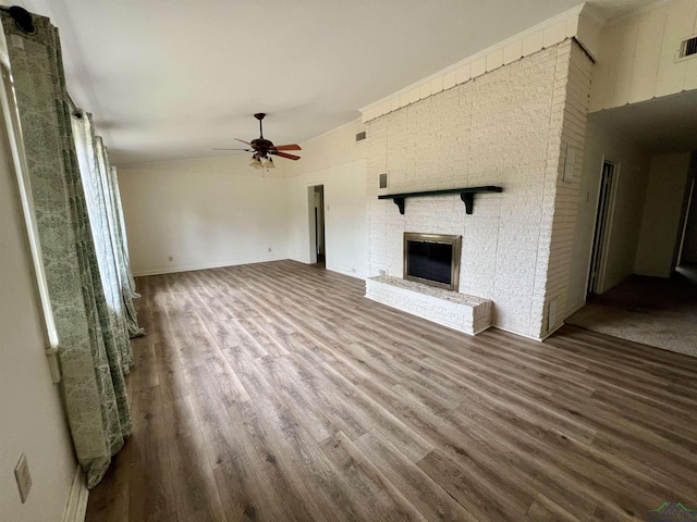 unfurnished living room with a brick fireplace, wood-type flooring, and ceiling fan