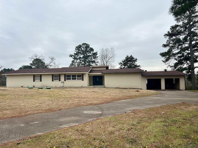 ranch-style home with a garage and a front lawn