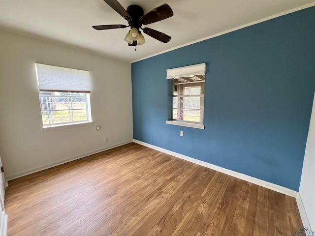 spare room featuring crown molding, ceiling fan, light hardwood / wood-style floors, and a wealth of natural light