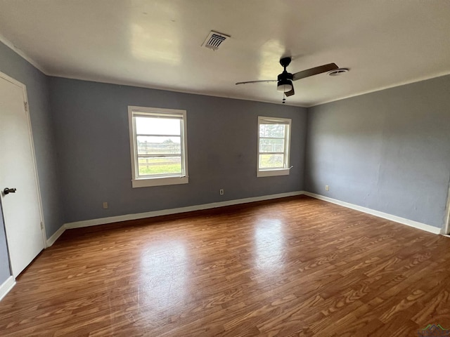 spare room featuring wood-type flooring, ornamental molding, and ceiling fan