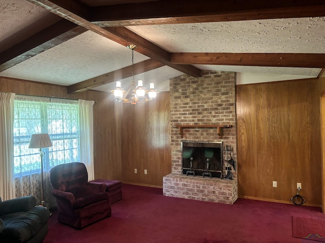 living room featuring a notable chandelier, wood walls, a textured ceiling, a fireplace, and carpet