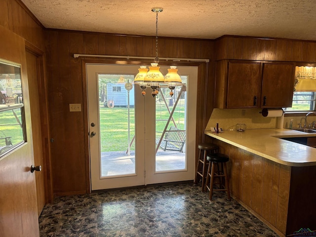 entryway with a textured ceiling, wooden walls, and sink