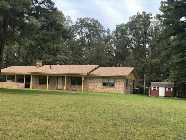 single story home featuring a front yard, a shed, and cooling unit