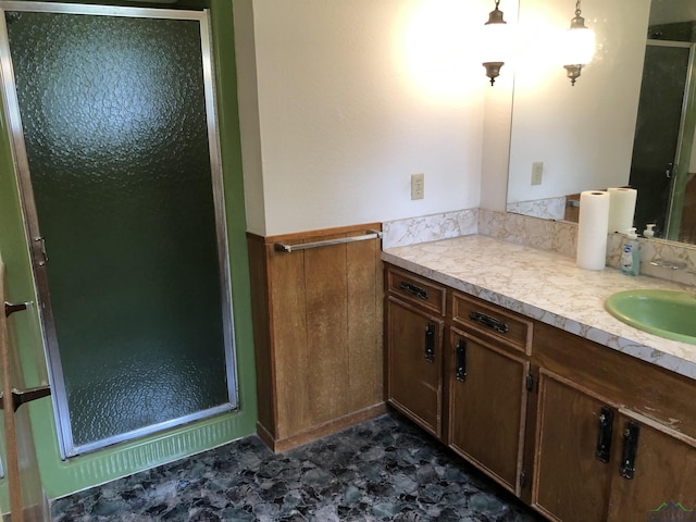 bathroom featuring vanity, wood walls, and a shower with door