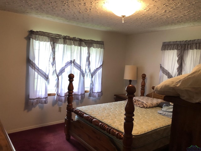 bedroom featuring a textured ceiling and dark carpet