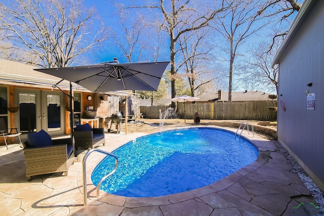 view of swimming pool featuring a fenced backyard, a fenced in pool, french doors, and a patio