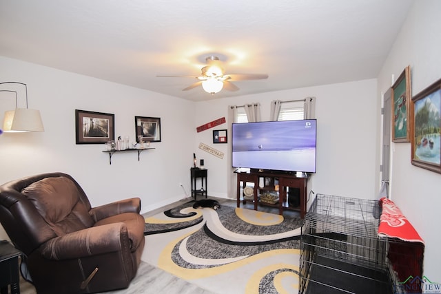 living area with ceiling fan, baseboards, and wood finished floors