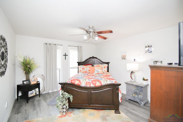 bedroom featuring light wood-type flooring, a ceiling fan, and baseboards