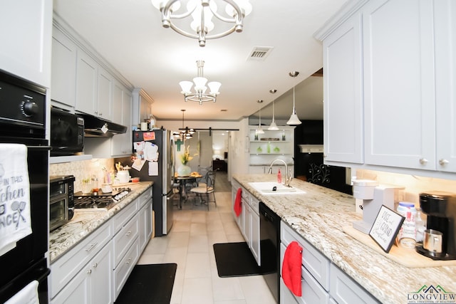 kitchen with a chandelier, a barn door, under cabinet range hood, visible vents, and black appliances