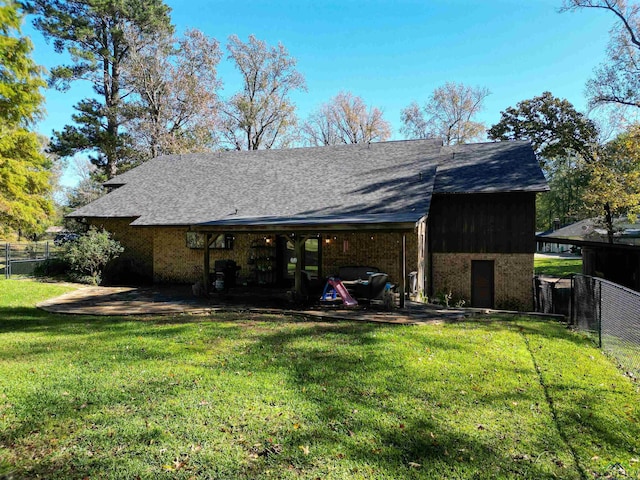 rear view of house featuring a lawn and a patio area