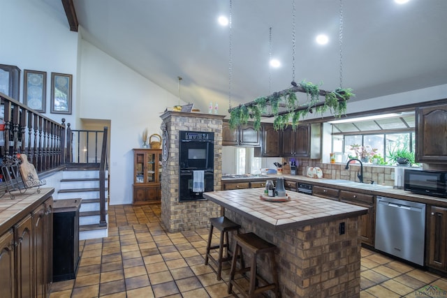 kitchen featuring tile counters, a kitchen island, black appliances, and dark brown cabinets