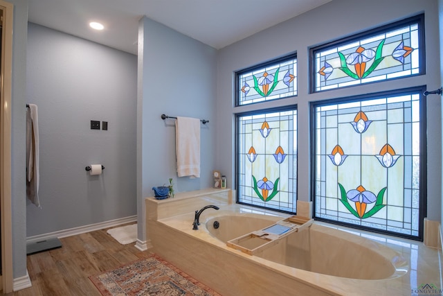 bathroom with a bathing tub and hardwood / wood-style floors