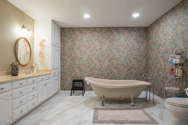 bathroom featuring a tub to relax in, vanity, and toilet