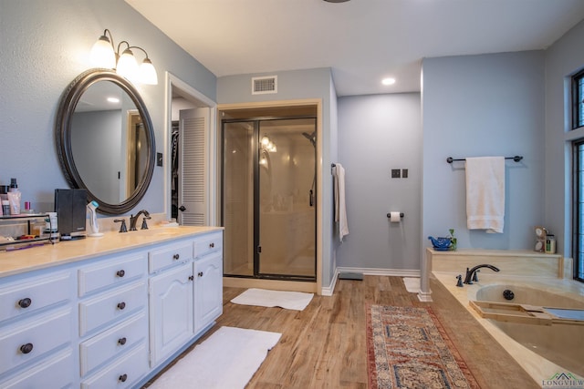 bathroom featuring vanity, wood-type flooring, and a shower with shower door