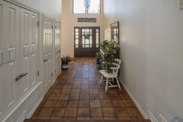 tiled entryway featuring a towering ceiling