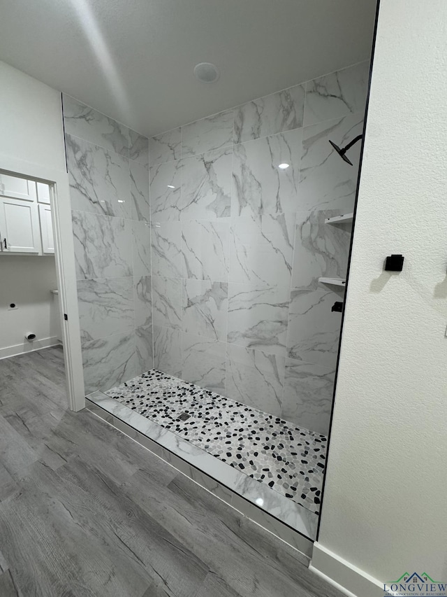 bathroom featuring hardwood / wood-style floors and a tile shower