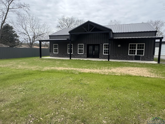 back of house featuring a lawn and french doors