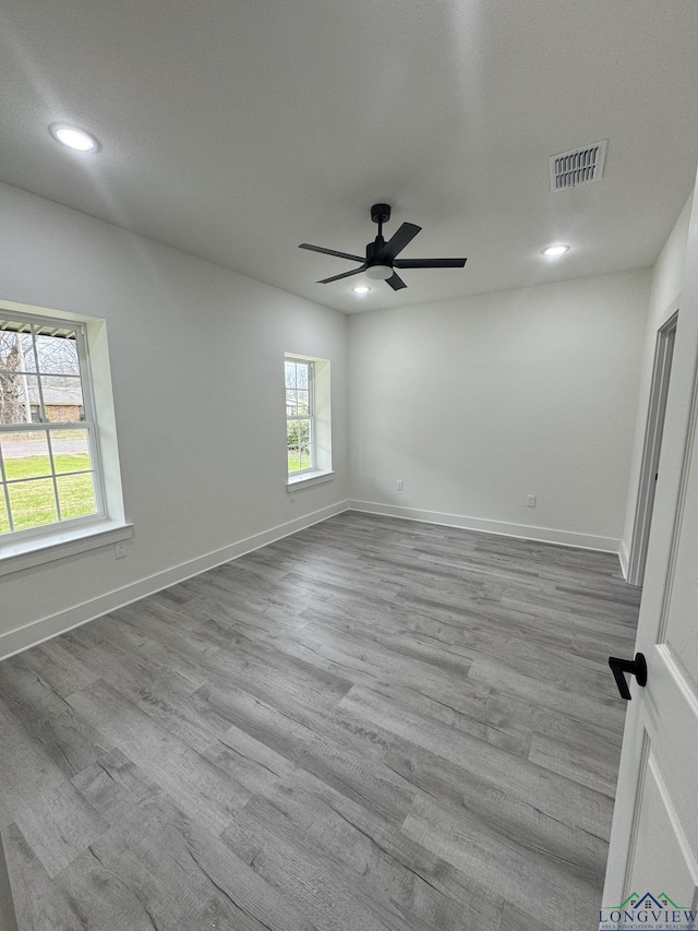 unfurnished room featuring ceiling fan, a wealth of natural light, and light hardwood / wood-style floors