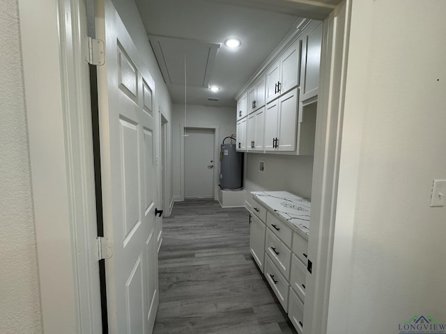 kitchen featuring white cabinetry, hardwood / wood-style floors, and water heater