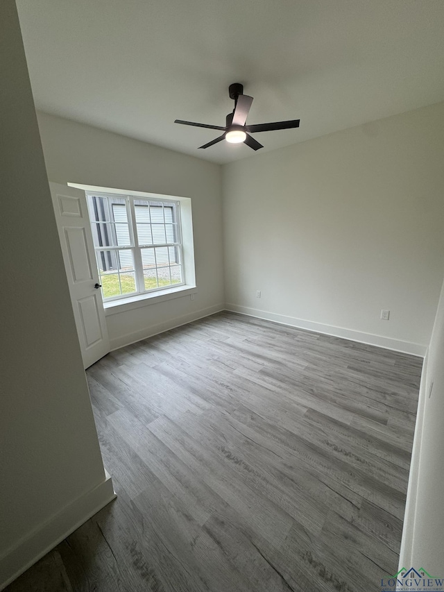 spare room with ceiling fan and light wood-type flooring