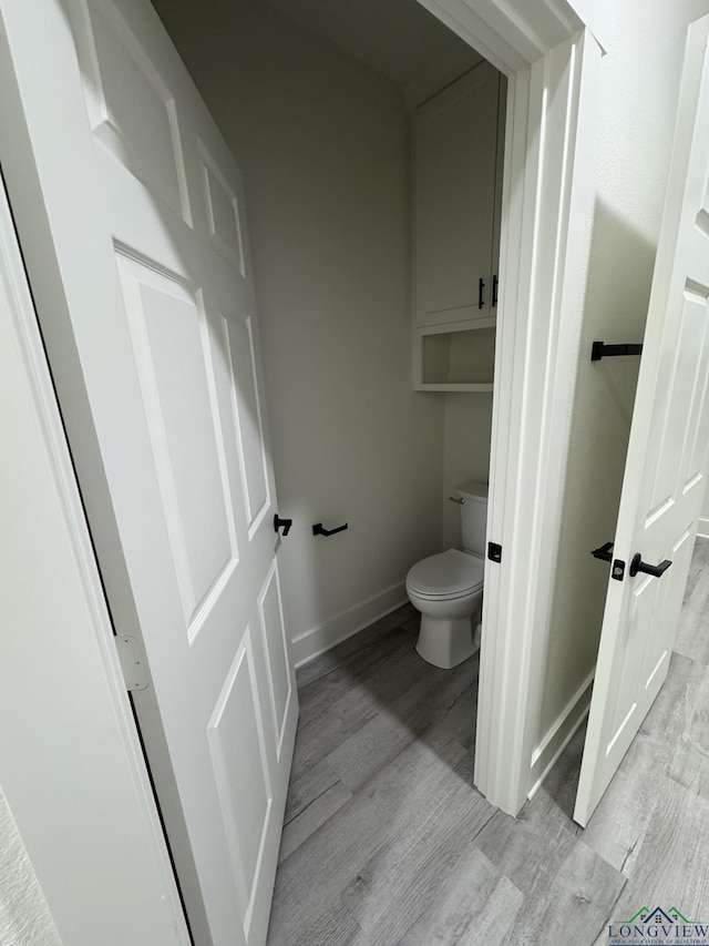 bathroom featuring hardwood / wood-style floors and toilet