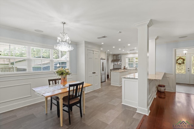 204 Delwood Dr, Longview, TX 75605 - dining area featuring crown molding, a chandelier, recessed lighting, wainscoting, and a decorative wall