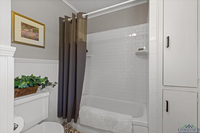 204 Delwood Dr, Longview, TX 75605 - bathroom with crown molding, shower / bath combo with shower curtain, a wainscoted wall, toilet, and a textured ceiling