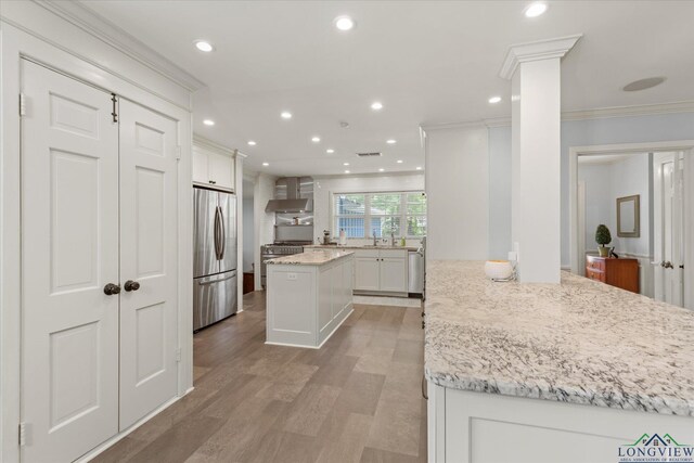 204 Delwood Dr, Longview, TX 75605 - kitchen featuring freestanding refrigerator, crown molding, light stone countertops, white cabinetry, and light wood-style floors