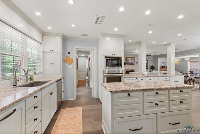 204 Delwood Dr, Longview, TX 75605 - kitchen with appliances with stainless steel finishes, ornamental molding, ornate columns, a sink, and a kitchen island
