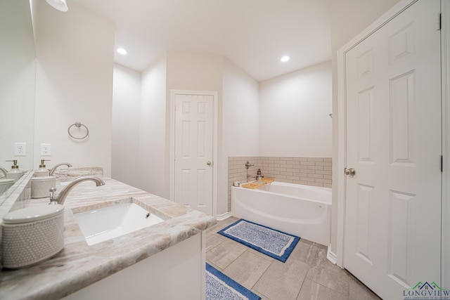 bathroom with tile patterned floors, vanity, and a bath