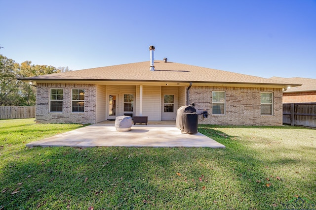 back of property with a lawn and a patio area