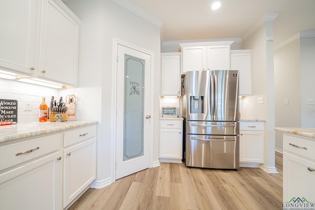 kitchen featuring stainless steel refrigerator with ice dispenser, light stone counters, ornamental molding, white cabinets, and light hardwood / wood-style floors