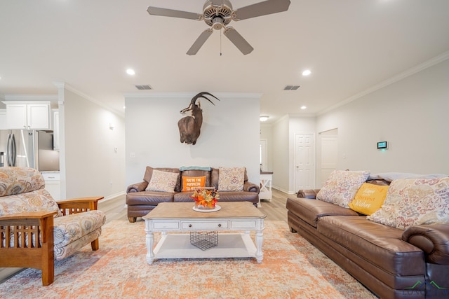 living room featuring ceiling fan, light hardwood / wood-style floors, and crown molding