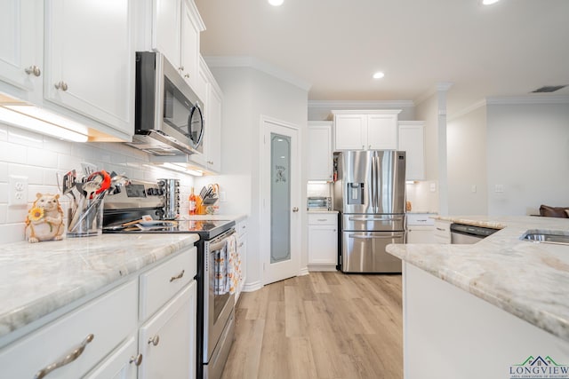 kitchen with appliances with stainless steel finishes, tasteful backsplash, white cabinetry, and light stone counters