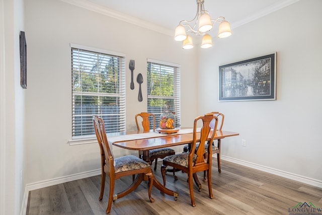 dining room with a chandelier, light wood-type flooring, and crown molding