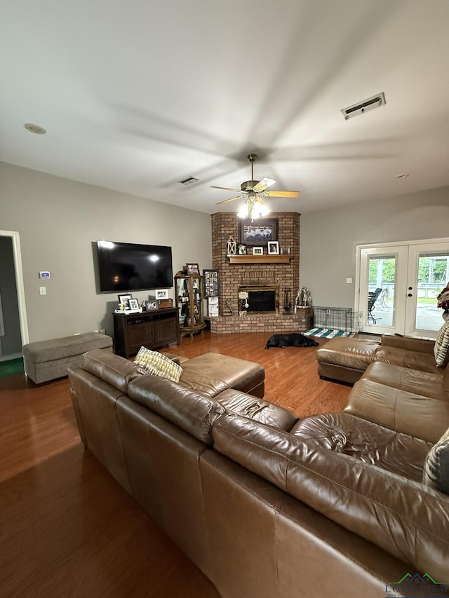 302 Meadowbrook Ln, Ore City, TX 75683 - living room featuring wood finished floors, ceiling fan, and a brick fireplace