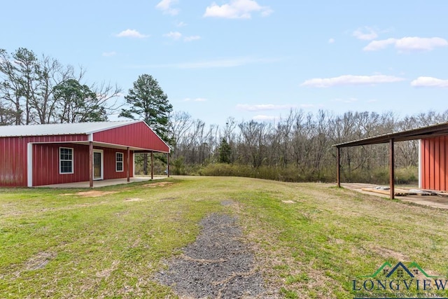 view of yard featuring an outbuilding, an outdoor structure, and driveway