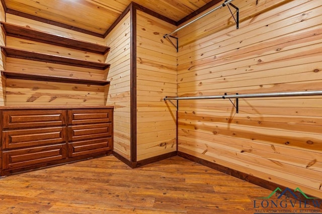 walk in closet with dark wood-type flooring