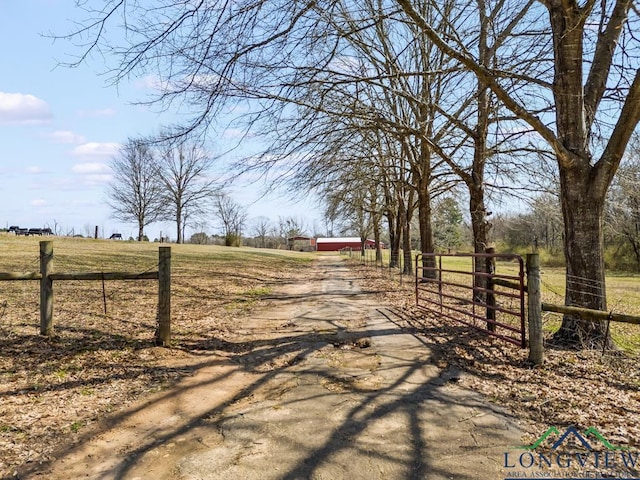 view of street with an outbuilding, a rural view, and driveway