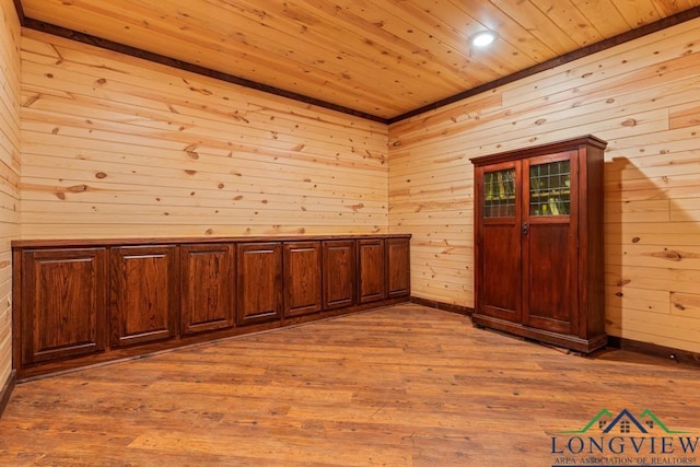 unfurnished room featuring wooden ceiling, wooden walls, wood finished floors, and baseboards