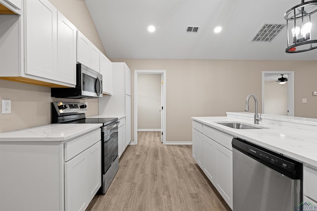 kitchen featuring light stone counters, visible vents, a sink, white cabinets, and appliances with stainless steel finishes