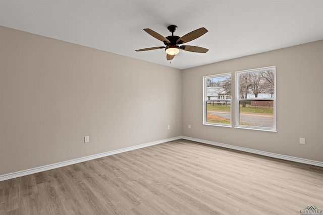 unfurnished room with baseboards, wood finished floors, and a ceiling fan