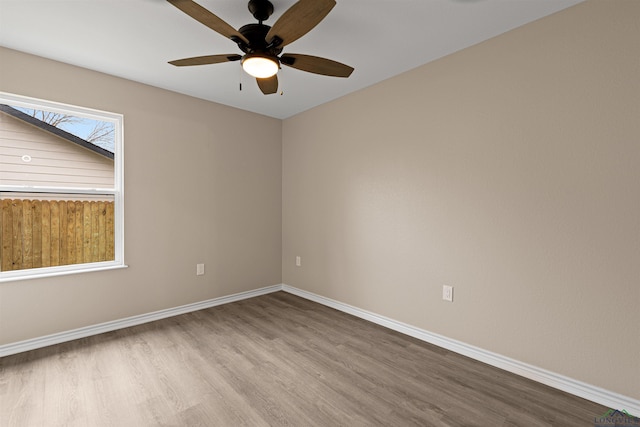 spare room featuring a ceiling fan, baseboards, and wood finished floors