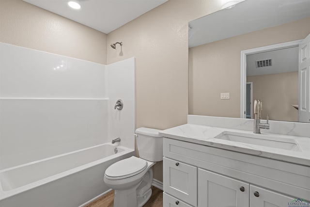 bathroom featuring vanity, wood finished floors, visible vents, shower / washtub combination, and toilet