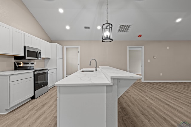 kitchen featuring lofted ceiling, visible vents, appliances with stainless steel finishes, and a sink