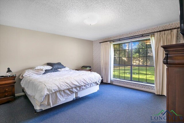 291 County Road 1130, Center, TX 75935 - carpeted bedroom with wallpapered walls and a textured ceiling