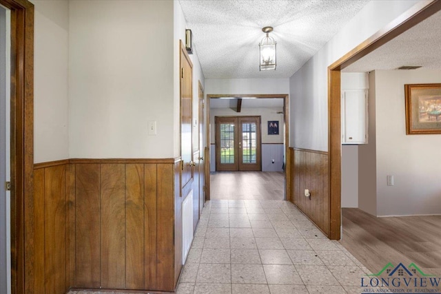 291 County Road 1130, Center, TX 75935 - hall featuring french doors, wainscoting, a textured ceiling, and wood walls