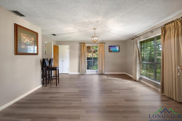 291 County Road 1130, Center, TX 75935 - dining room with healthy amount of natural light, a chandelier, wood finished floors, and a textured ceiling