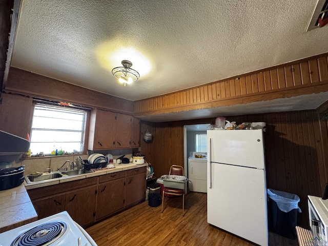 kitchen featuring a sink, washer / dryer, tile countertops, and freestanding refrigerator