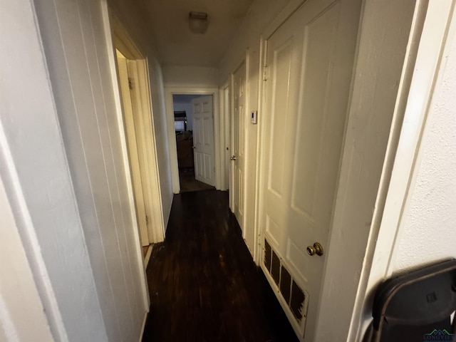 hallway featuring dark wood finished floors and visible vents